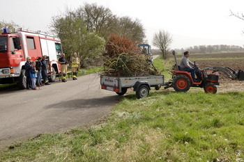 Ein Trecker bringt Brenngut zum Osterfeuer in Elbenau